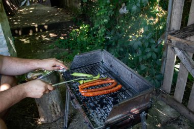 Kömür barbekü ızgarası. Kömür mangalı. Kömür mangalı. Kömür ızgarası, ızgara sosis ve ızgarada yeşil biber.