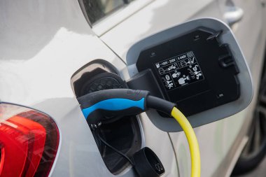 EV için kamu şarj istasyonu (elektrikli araç), şarj için prize bağlı araç, CO2 ve yeşil enerjinin azaltılması, eko ve çevre dostu, yenilenebilir enerji