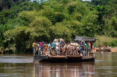 İnsanları Mbari Nehri 'nden yerel kanolarla ve feribotla geçirmek. Hafta sonu yerel pazardan satın alınan çeşitli ürünlerin rengarenk giysileri ve nakliyesi