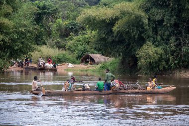 İnsanları Mbari Nehri 'nden yerel kanolarla ve feribotla geçirmek. Hafta sonu yerel pazardan satın alınan çeşitli ürünlerin rengarenk giysileri ve nakliyesi
