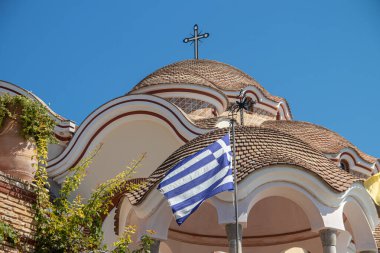 View on backyard of Monastery of Archangel Michael in Greece, Thasos Island, with vivid orange walls and roof, monastery was build at the cliff over the Aegean Sea, which first began as a men's only monastery at the start of the 20th century