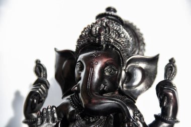 Beyaz arkaplanı olan Ganesh 'in siyah heykelciği.