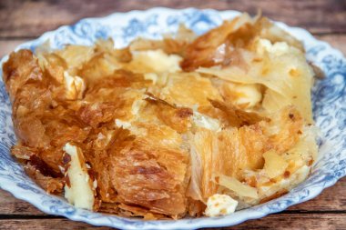 Sırp yemeği Burek (peynir turtası), kahvaltıda sofrada çatal bıçak takımı ve sarı fincanda taze yoğurt ile servis ediliyor. Sağlıklı besleyici yemek