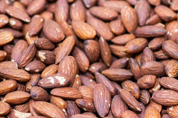 Dried and roasted almonds close up in street market healthy food shop, organically grown