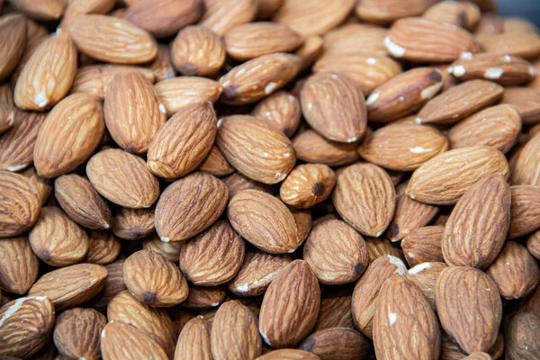 Dried and roasted almonds close up in street market healthy food shop, organically grown