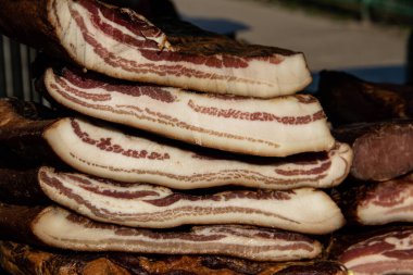 Korunmasız pastırma ve kurutulmuş et yerli ürünleri, Kacarevo köyündeki bir çiftçi pazarında, Slaninijada (pastırma festivali) adlı domuz pastırması ve kurutulmuş et ürünleri festivali Belgrad yakınlarındaki Kacarevo 'da her yıl düzenlendi.