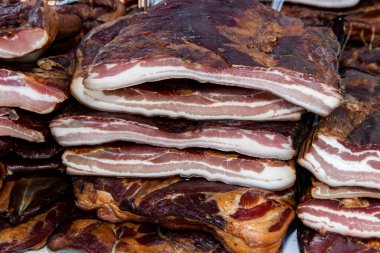 Korunmasız pastırma ve kurutulmuş et yerli ürünleri, Kacarevo köyündeki bir çiftçi pazarında, Slaninijada (pastırma festivali) adlı domuz pastırması ve kurutulmuş et ürünleri festivali Belgrad yakınlarındaki Kacarevo 'da her yıl düzenlendi.