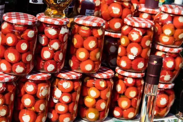 Homemade canned vegetables in cans, pickled small cherry tomatoes stuffed with cheese and onion, in a rural style of Serbian country side