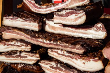 Korunmasız pastırma ve kurutulmuş et yerli ürünleri, Kacarevo köyündeki bir çiftçi pazarında, Slaninijada (pastırma festivali) adlı domuz pastırması ve kurutulmuş et ürünleri festivali Belgrad yakınlarındaki Kacarevo 'da her yıl düzenlendi.