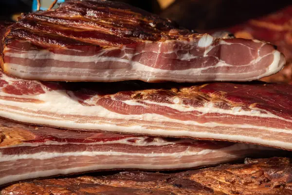 Korunmasız pastırma ve kurutulmuş et yerli ürünleri, Kacarevo köyündeki bir çiftçi pazarında, Slaninijada (pastırma festivali) adlı domuz pastırması ve kurutulmuş et ürünleri festivali Belgrad yakınlarındaki Kacarevo 'da her yıl düzenlendi.