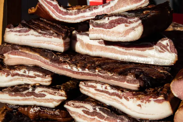 Korunmasız pastırma ve kurutulmuş et yerli ürünleri, Kacarevo köyündeki bir çiftçi pazarında, Slaninijada (pastırma festivali) adlı domuz pastırması ve kurutulmuş et ürünleri festivali Belgrad yakınlarındaki Kacarevo 'da her yıl düzenlendi.