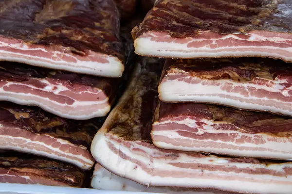 Korunmasız pastırma ve kurutulmuş et yerli ürünleri, Kacarevo köyündeki bir çiftçi pazarında, Slaninijada (pastırma festivali) adlı domuz pastırması ve kurutulmuş et ürünleri festivali Belgrad yakınlarındaki Kacarevo 'da her yıl düzenlendi.