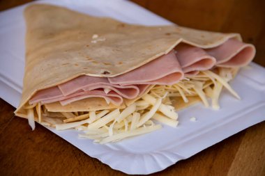 Jambon ve erimiş peynirle dolu leziz bir krep lezzetli bir lezzet kombinasyonu sunar. Gözlemenin altın gibi, çıtır çıtır dışı doyurucu ve doyurucu bir yemek için sıcak ve lezzetli bir dolgu içerir..