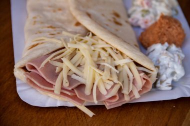 Jambon ve erimiş peynirle dolu leziz bir krep lezzetli bir lezzet kombinasyonu sunar. Gözlemenin altın gibi, çıtır çıtır dışı doyurucu ve doyurucu bir yemek için sıcak ve lezzetli bir dolgu içerir..