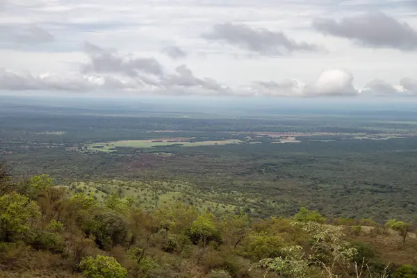 stock image A breathtaking view of Omo Valley in Ethiopia showcases a vast, lush landscape. A winding dirt road meanders through the valley, drawing the eye to distant hills and mountains, adding depth and tranquility to the serene setting