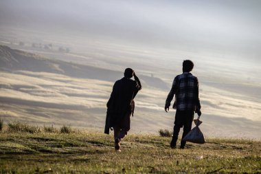 Etiyopya manzarası ve doğası üzerinde güzel bir sabah manzarası. Yerel nüfusun silueti geleneksel olarak giyinmiş, sonsuz vadilerde yürüyor. 