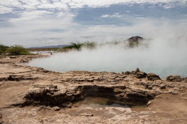 Alolabad geothermal area in Ethiopia with surreal landscape of colorful hot springs, steaming fumaroles, and erupting salt geysers in an arid, remote desert setting below sea level, Afar desert. Temperature of water is up to 112C  clipart