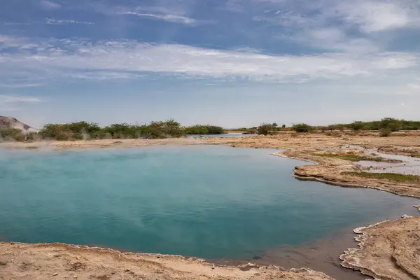 stock image Alolabad geothermal area in Ethiopia with surreal landscape of colorful hot springs, steaming fumaroles, and erupting salt geysers in an arid, remote desert setting below sea level, Afar desert. Temperature of water is up to 112C 