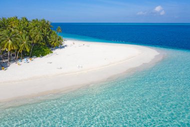 Maldivler 'de küçük bir ada. Palmiyelerle kaplı ve turkuvaz mavisi sularla çevrili. Güzel mercanları ve hayvanları var.