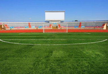 Mavi gökyüzünde gol ve tablo ile futbol sahası