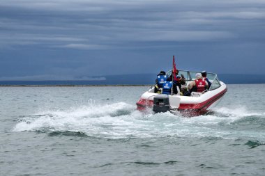 Beyaz bir tekne kıyı boyunca tam gaz gider. Yandan fotoğraf, yüksek kalite fotoğraf.