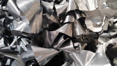 Steel scrap materials recycling. Aluminum chip waste after machining metal parts on a cnc lathe. Closeup twisted spiral steel shavings. Small roughness sharpness,. High quality photo clipart