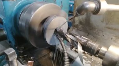 Dönen torna makinesinde metal bir silindiri kesen matkabın yakın çekimi. Yüksek kaliteli FullHD görüntüler