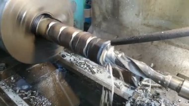 Dönen torna makinesinde metal bir silindiri kesen matkabın yakın çekimi. Yüksek kaliteli FullHD görüntüler