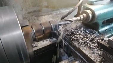 Dönen torna makinesinde metal bir silindiri kesen matkabın yakın çekimi. Yüksek kaliteli FullHD görüntüler