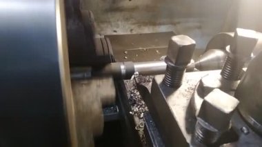 Dönüştürücünün yakın çekimi torna tezgahındaki metal parçayı işliyor. Yüksek kaliteli FullHD görüntüler