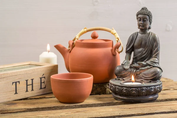 茶的时间仍然是清纯的亚洲风格 茶壶和佛像都配有蜡烛 免版税图库照片