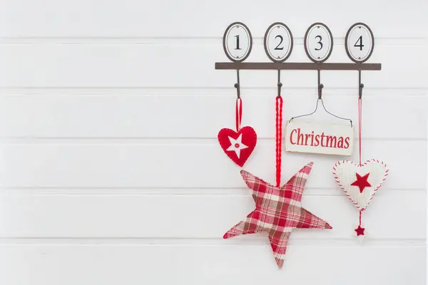 1から4までの数字と赤と白のクリスマスの装飾要素を掛けるヴィンテージスタイルのホックレール ストック写真