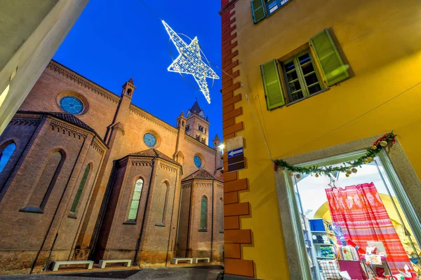 サンロレンツォ大聖堂の低角度ビュー 窓や木製のシャッターとイタリアのアルバで夜に照らされた星型のクリスマスの装飾と建物 — ストック写真