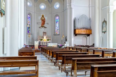 ALBA, ITALY - JUNE 23, 2020: View of pews, altar and organ inside of Divin Maestro - a roman catholic parish church recently renovated, located in small town of Alba in Piedmont, Northern Italy.