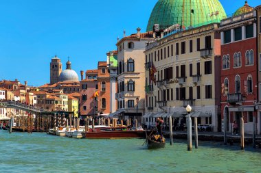 VENICE, İTALYA - 06 Nisan 2023: Venedik 'te tekneleri ve gondollu Grand Canal boyunca eski tarihi binalar - 118 küçük adadan oluşan bir grup üzerine inşa edilmiş,.