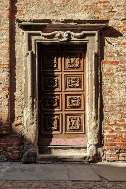 Alba, Piedmont, Kuzey İtalya 'da (dikey kompozisyon) eski ahşap kapı ve eski tuğla duvar).