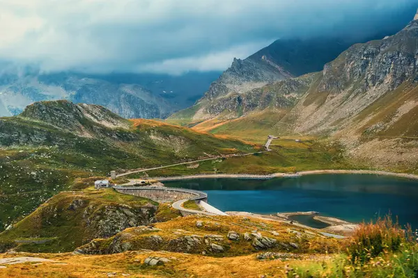 Küçük alp gölü Agnel dağların arasında bulutlu gökyüzünün altında İtalya 'daki Nivolet dağı geçidi yakınlarında..