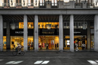 TURIN, ITALY - 28 Mayıs 2024: İnsanlar Torino 'da sütunları olan kapalı bir galeride butiklerin önünden geçiyorlar - başkent Piedmont ve Kuzey İtalya' daki önemli iş ve kültür merkezleri.