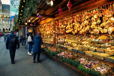 Viyana, AUSTRIA - 03 Aralık 2019: Rathausplatz 'daki insanlar, Viyana' daki Noel pazarında Noel oyuncakları ve süslemelerle ahşap tezgahlar boyunca yürüyorlar..