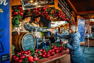 Viyana, AUSTRIA - 4 Aralık 2019: Kadınlar Viyana 'daki yıllık Noel pazarından sıcak sıcak sıcak sıcak sıcak şarap satın alır - Avrupa' nın en popüler Noel fuarlarından biridir..