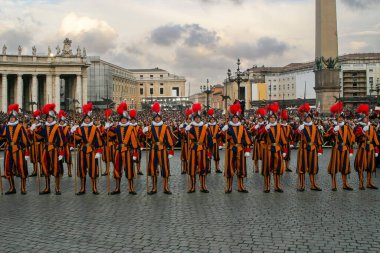 VATICAN, VATICAN - 19 Nisan 2005: İsviçreli muhafız, Vatikan 'ın Vatikan şehrinde Vatikan' ın başkenti Vatikan 'da yeni bir Papa seçildikten sonra Aziz Peter Meydanı' nda forma girmiş ve tüylü miğferleriyle ayakta duruyor..