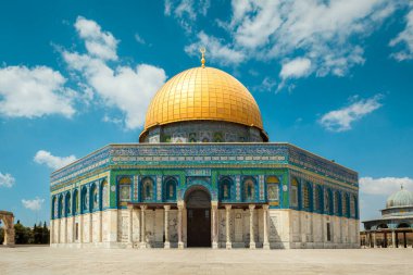 İsrail 'in Kudüs şehrinde, tüylü beyaz bulutlarla kaplı parlak mavi gökyüzüne karşı duran ünlü Kubbe Kaya Camii..