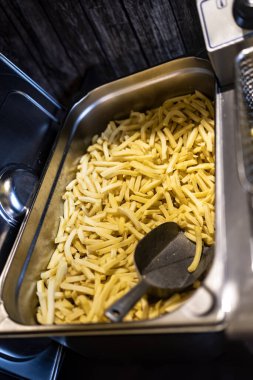 Patates kızartması ve kürekle dolu metal bir konteynır..