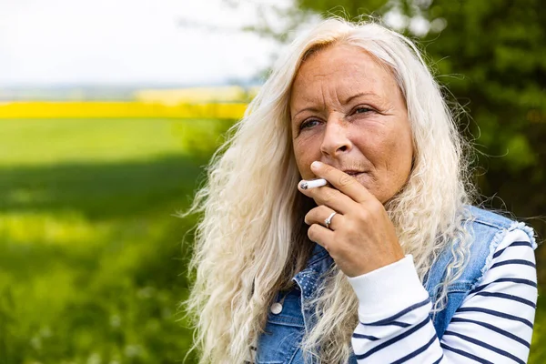 一个女人在户外抽烟的画像 — 图库照片