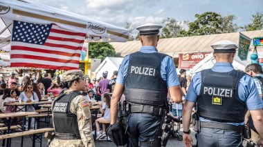 WIESBADEN, HESSE, GERMANY - 07-03-2023 - Wiesbaden 'de düzenlenen Alman Amerikan Dostluk Festivali' nde iki Alman polis memuru ve bir Amerikan askeri kadın kurşun geçirmez yelek giymişti...