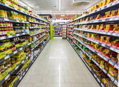 HUETTENBERG, HESSE, GERMANY _ 12 _ 05 _ 2022: Bir Alman süpermarketinde yiyecek ürünleriyle dolu raflarla dolu koridor.