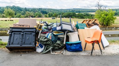 Bulky waste at the roadside with old furniture and various household items clipart