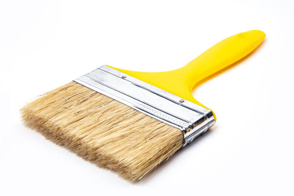 Wide paint brush with yellow handle isolated of white background