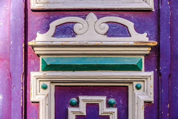 Detail from handmade purple wooden door with inlays