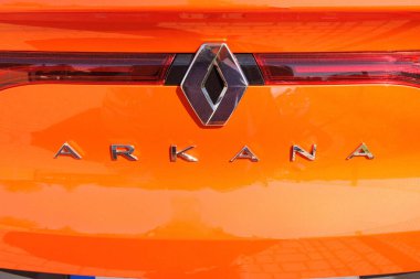 QUEDLINBURG, SAXONY-ANHALT - GERMANY - 09-04-2023: RENAULT ARKANA LOGO kromu ve markası Fransız çokuluslu otomobil üreticisi turuncu araç.